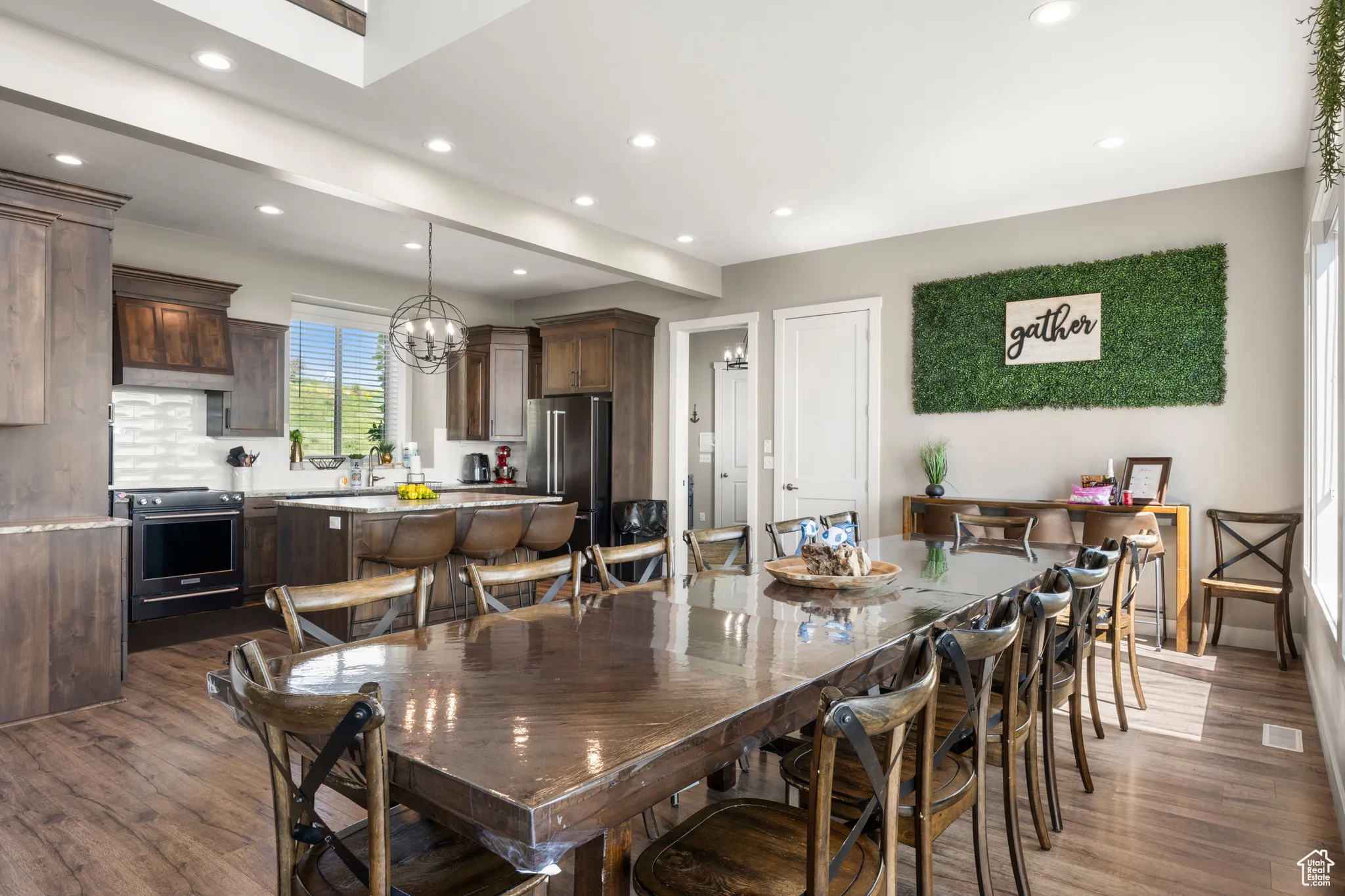 Dining space with dark wood-type flooring, recessed lighting, and a chandelier