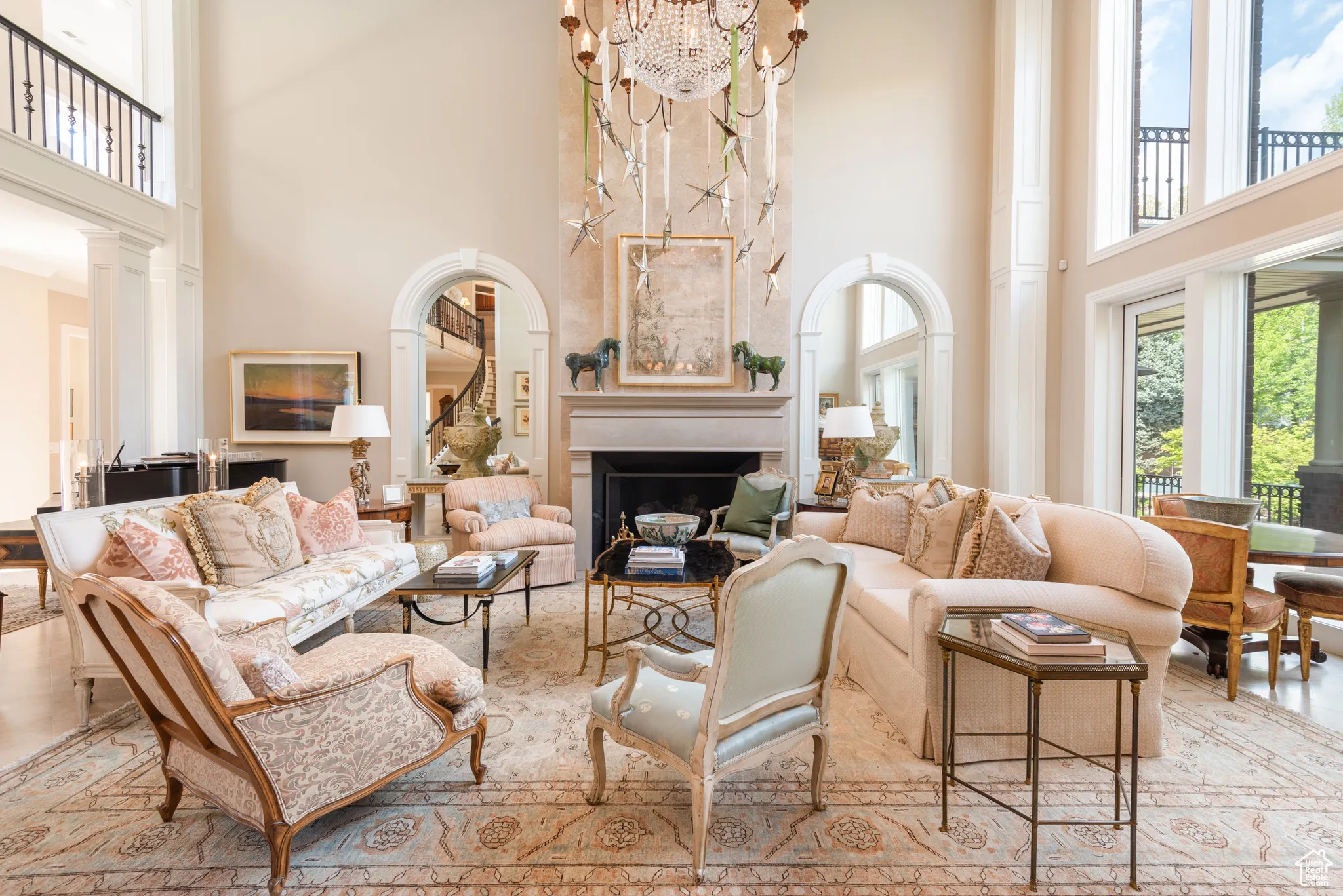 Living area with a towering ceiling, a fireplace, and a chandelier