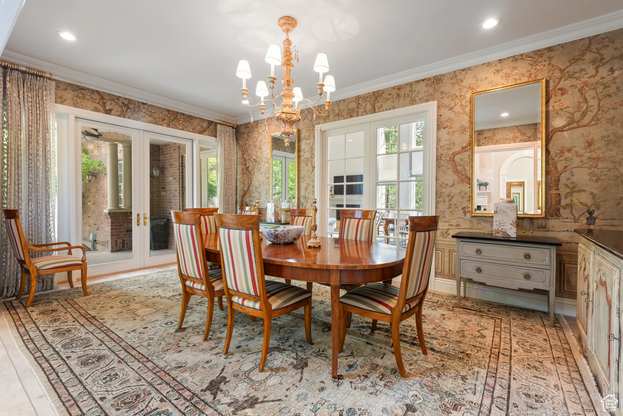 Dining area featuring wallpapered walls, a chandelier, ornamental molding, french doors, and recessed lighting