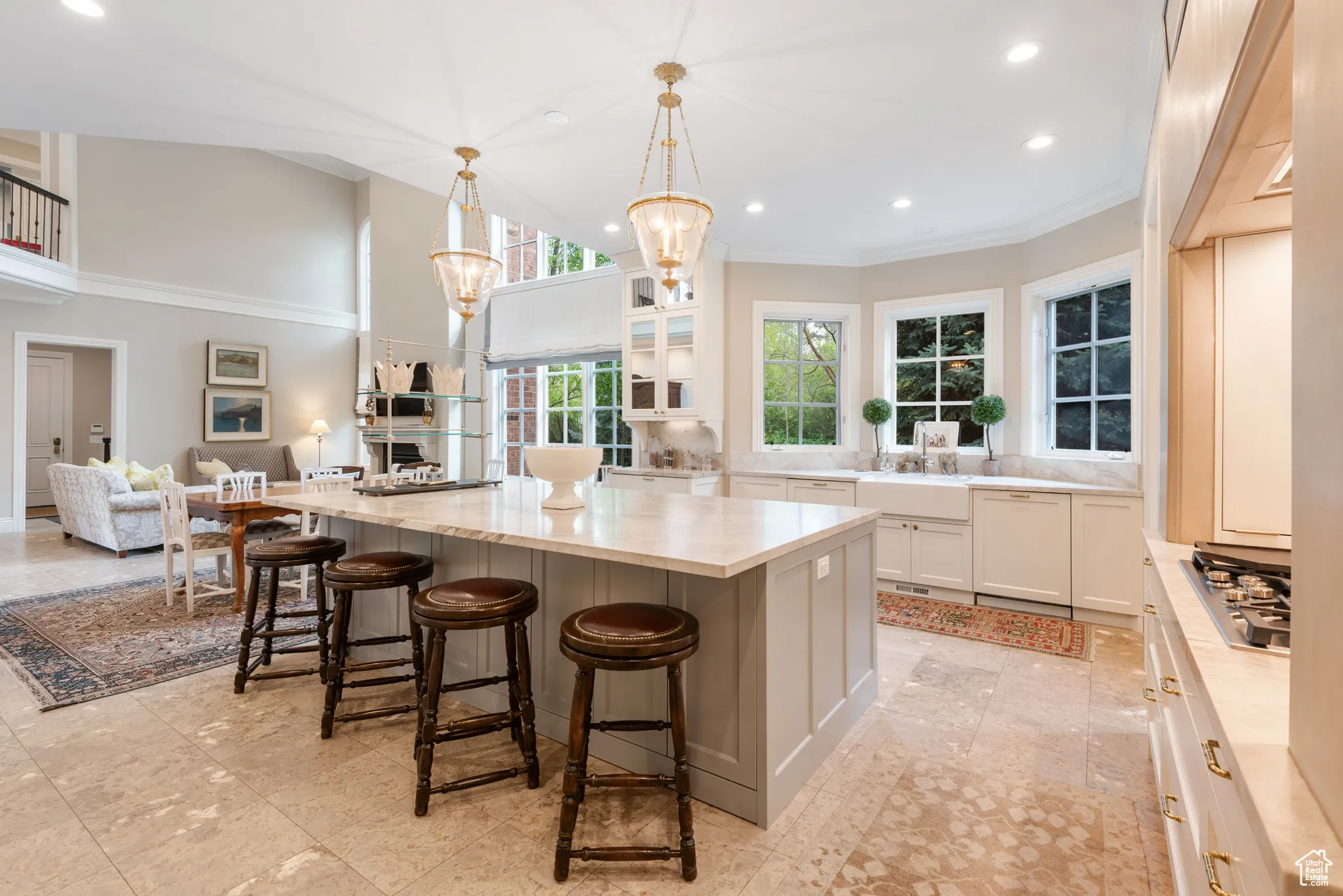 Kitchen featuring stainless steel gas stovetop, recessed lighting, white cabinets, ornamental molding, and light stone counters