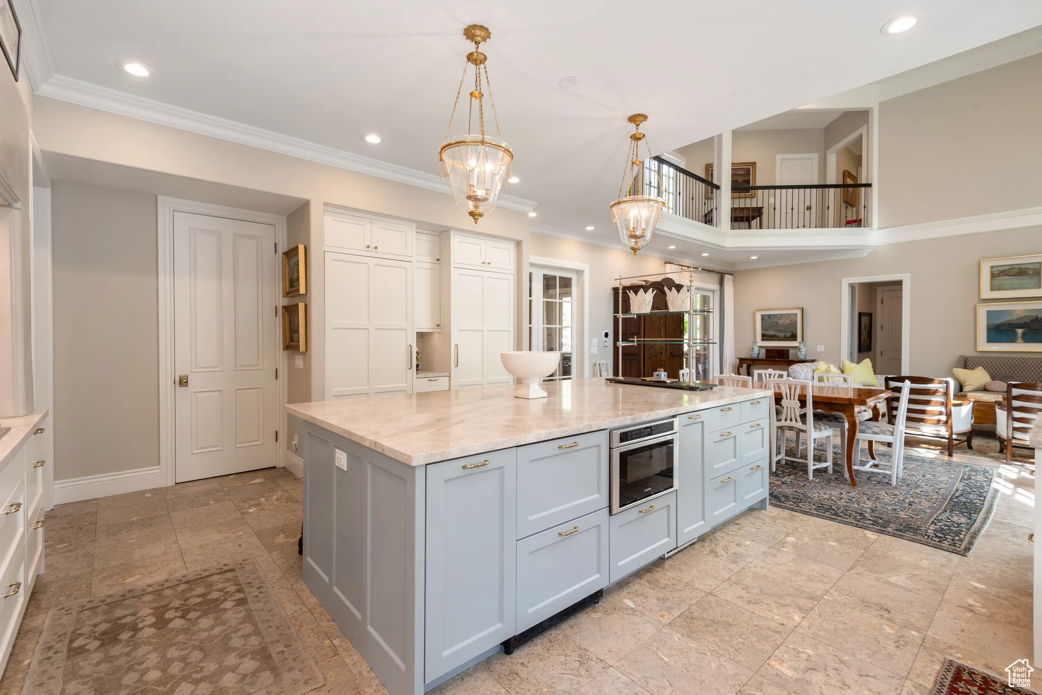 Kitchen with a chandelier, recessed lighting, crown molding, light stone counters, and decorative light fixtures