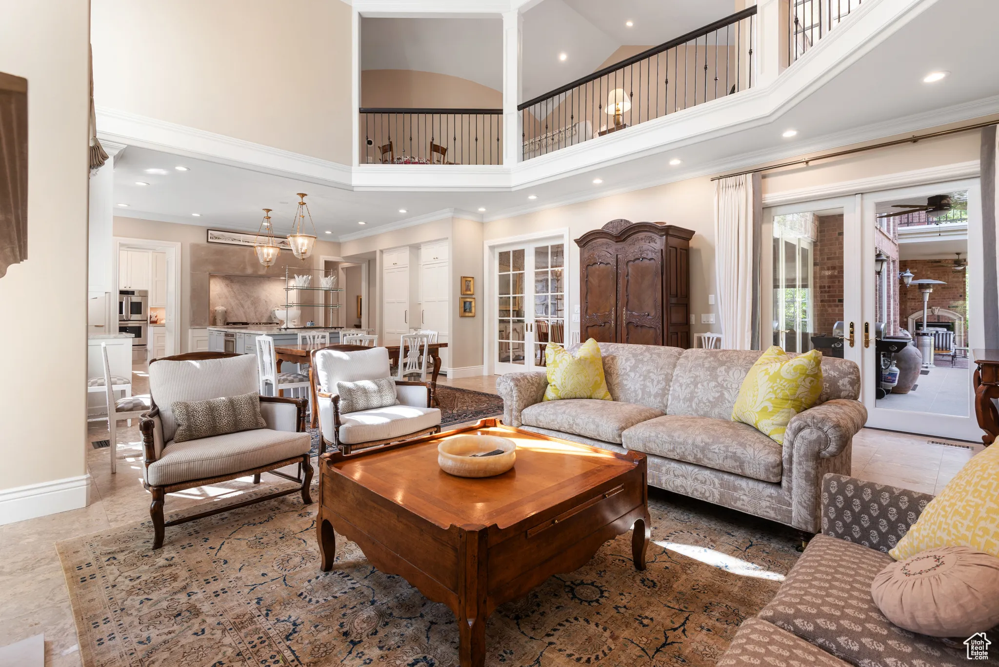 Living area featuring a towering ceiling, recessed lighting, baseboards, and ornamental molding