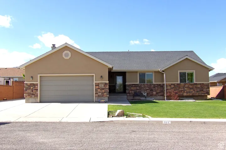 View of front facade featuring stucco siding, stone siding, a garage, concrete driveway, and roof with shingles