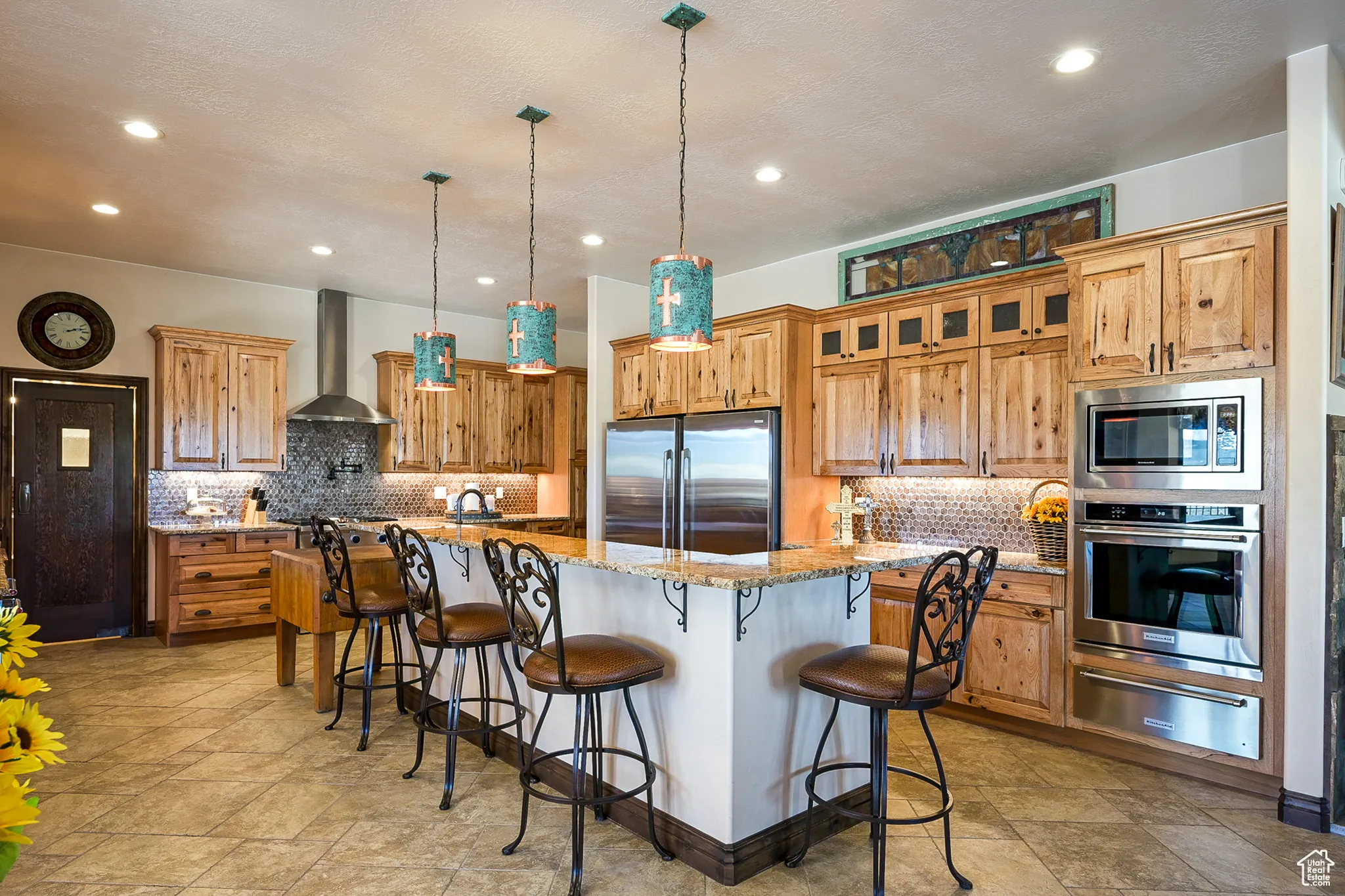 Kitchen featuring stainless steel appliances, wall chimney exhaust hood, a warming drawer, backsplash, and recessed lighting