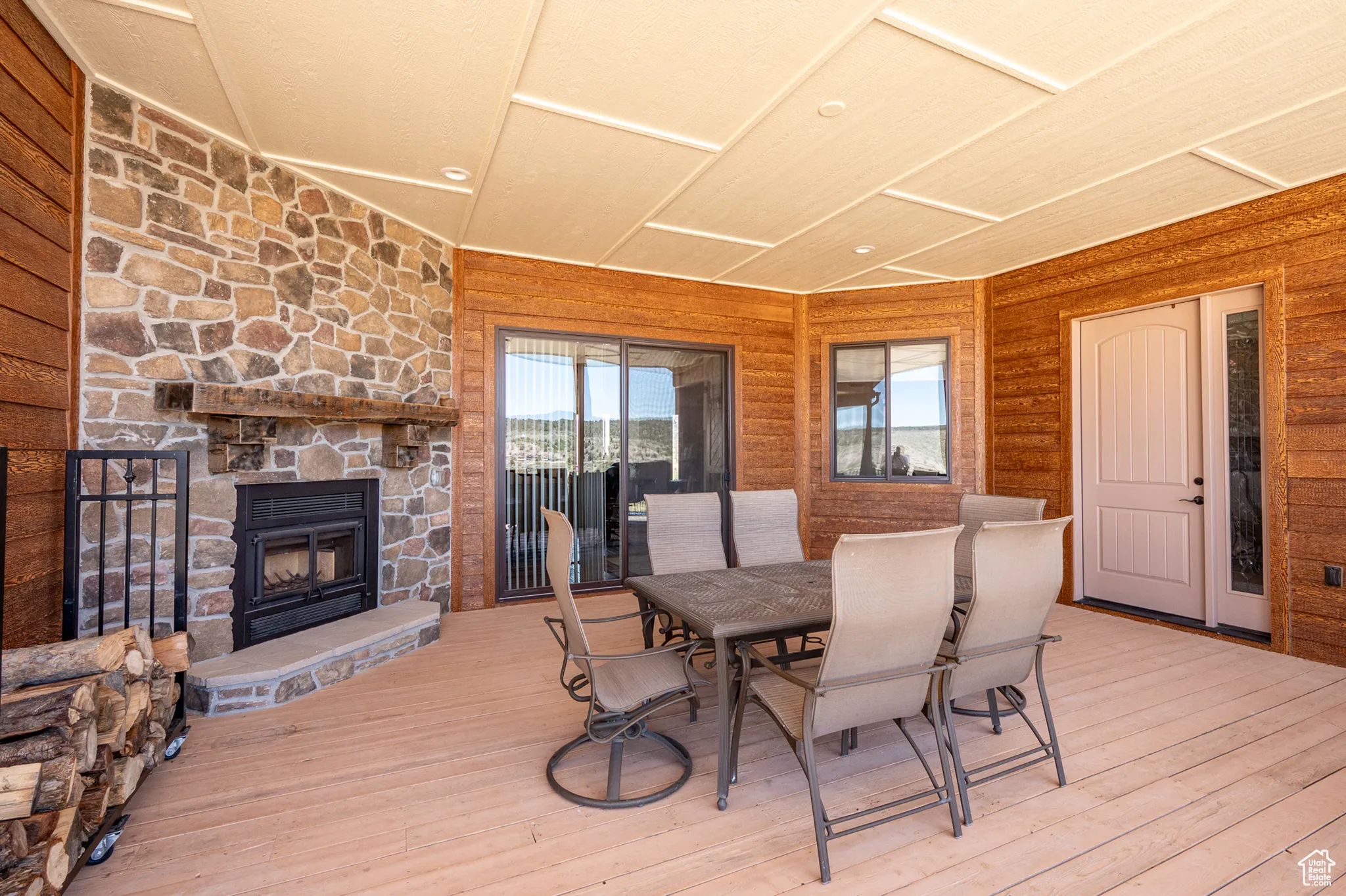 Back deck featuring a stone fireplace and outdoor dining area