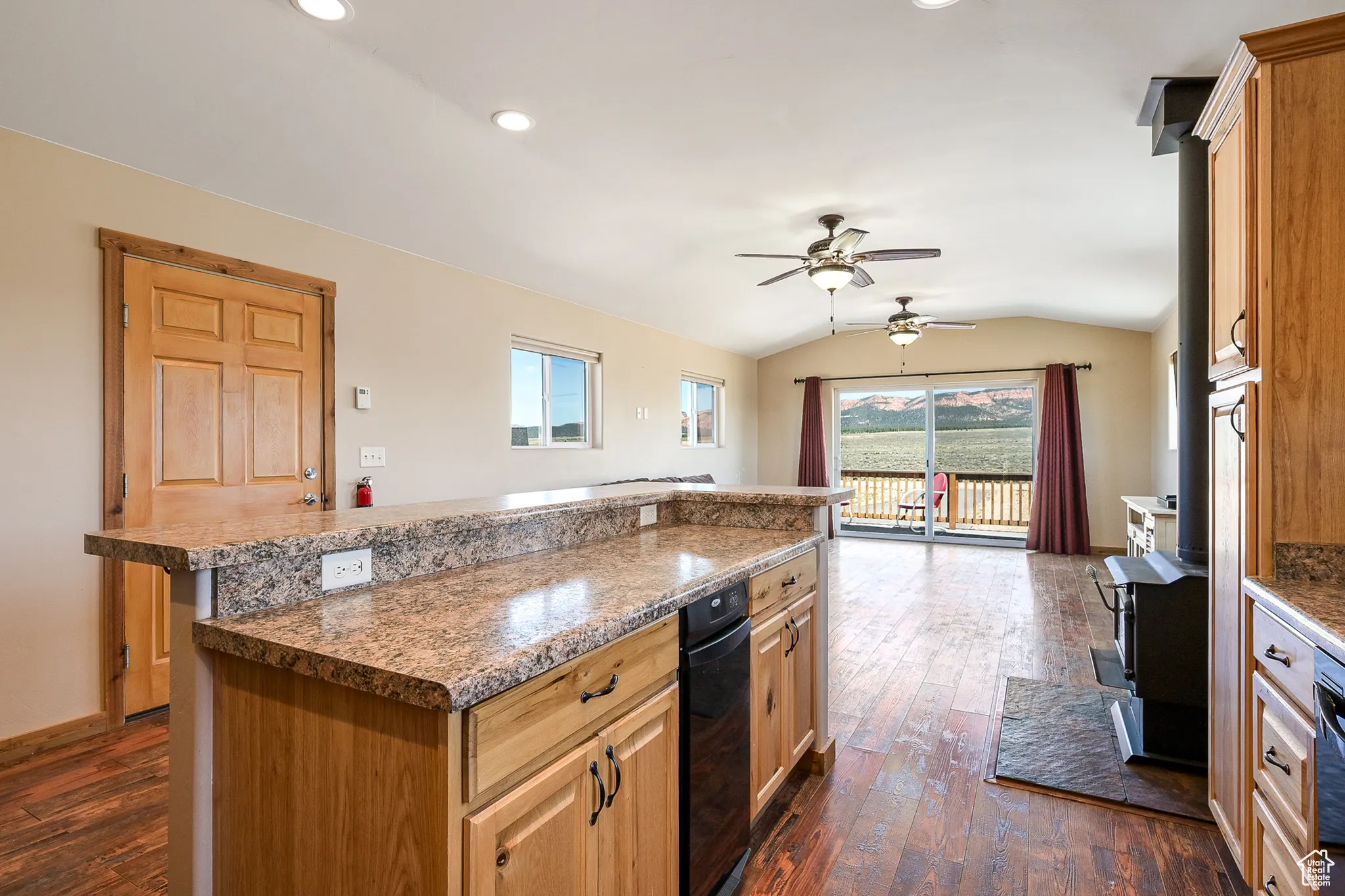 Barn upstairs apartment kitchen with vaulted ceiling, a ceiling fan, dark wood-type flooring, a center island, and recessed lighting
