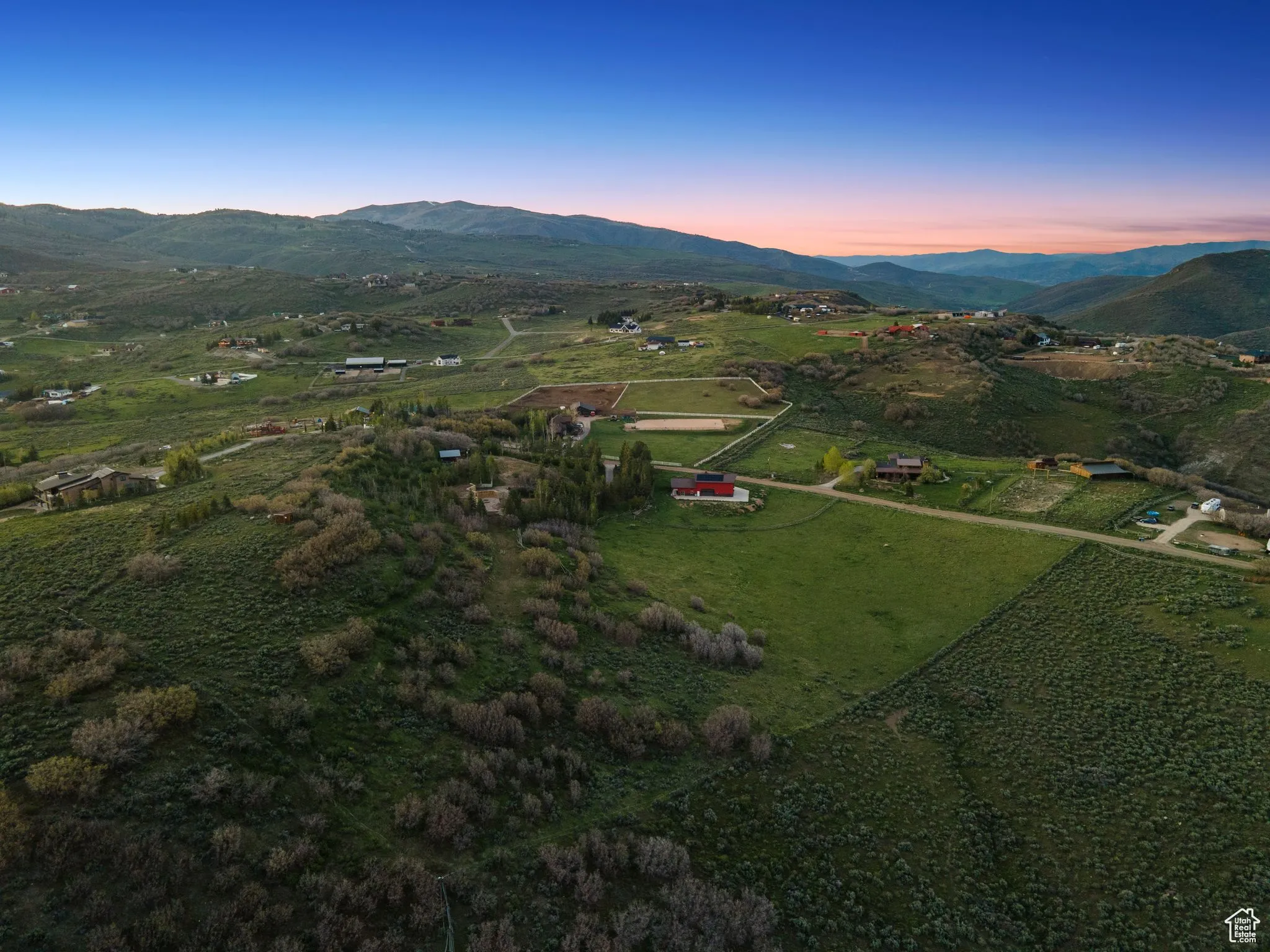 Aerial overview of property's location featuring a mountainous background and rural landscape