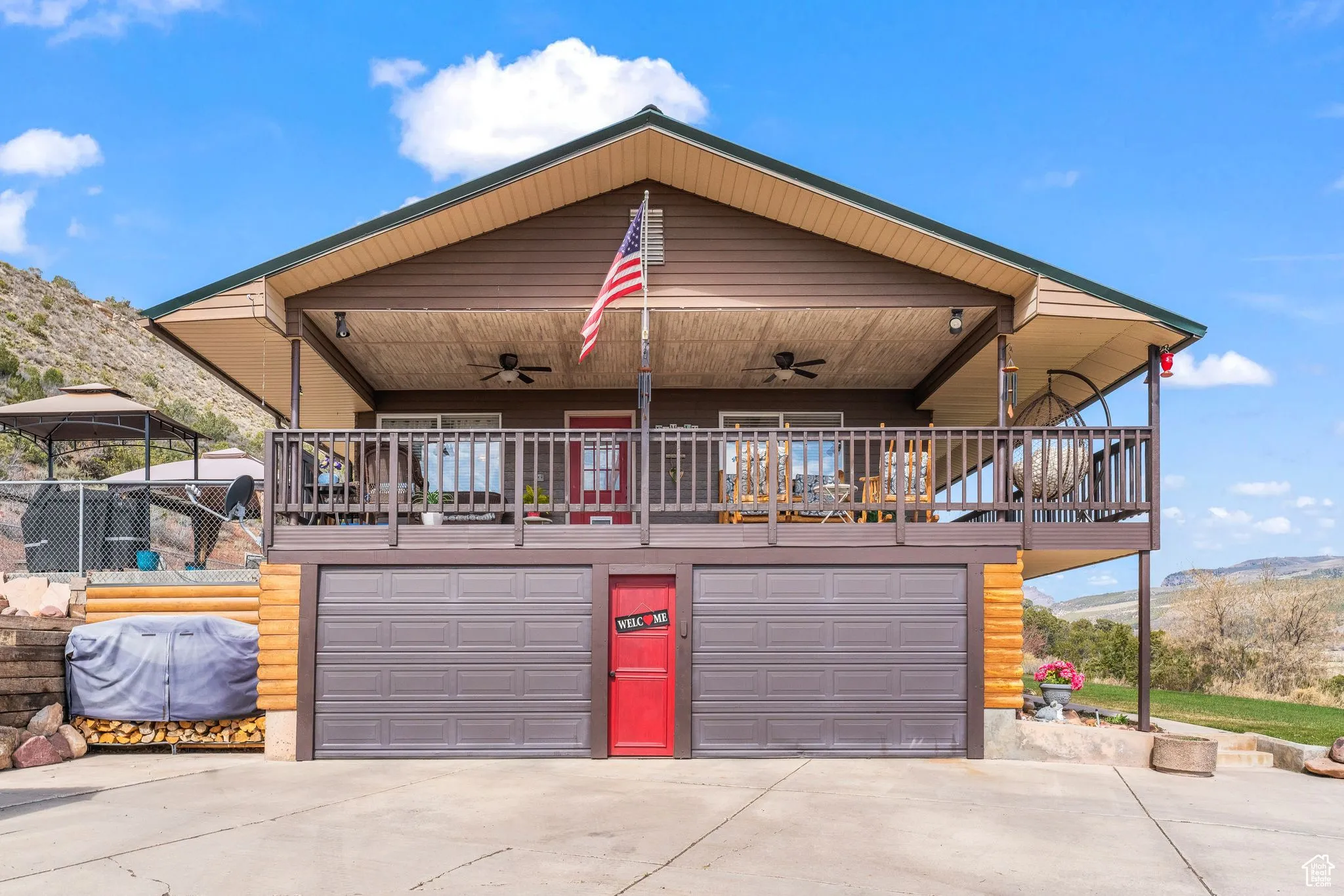 View of front of property featuring ceiling fan, driveway, a garage, and a mountain view