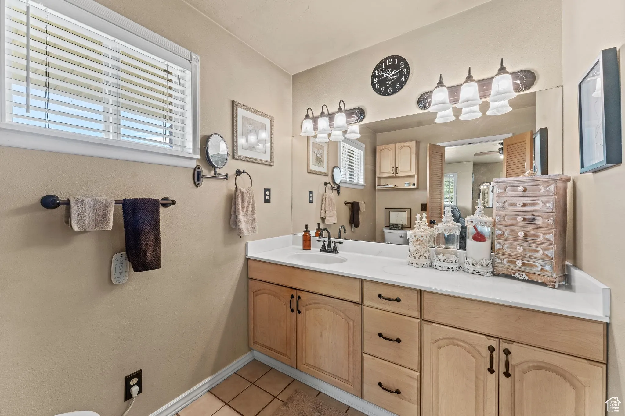 Bathroom with tile patterned floors, healthy amount of natural light, vanity, and baseboards