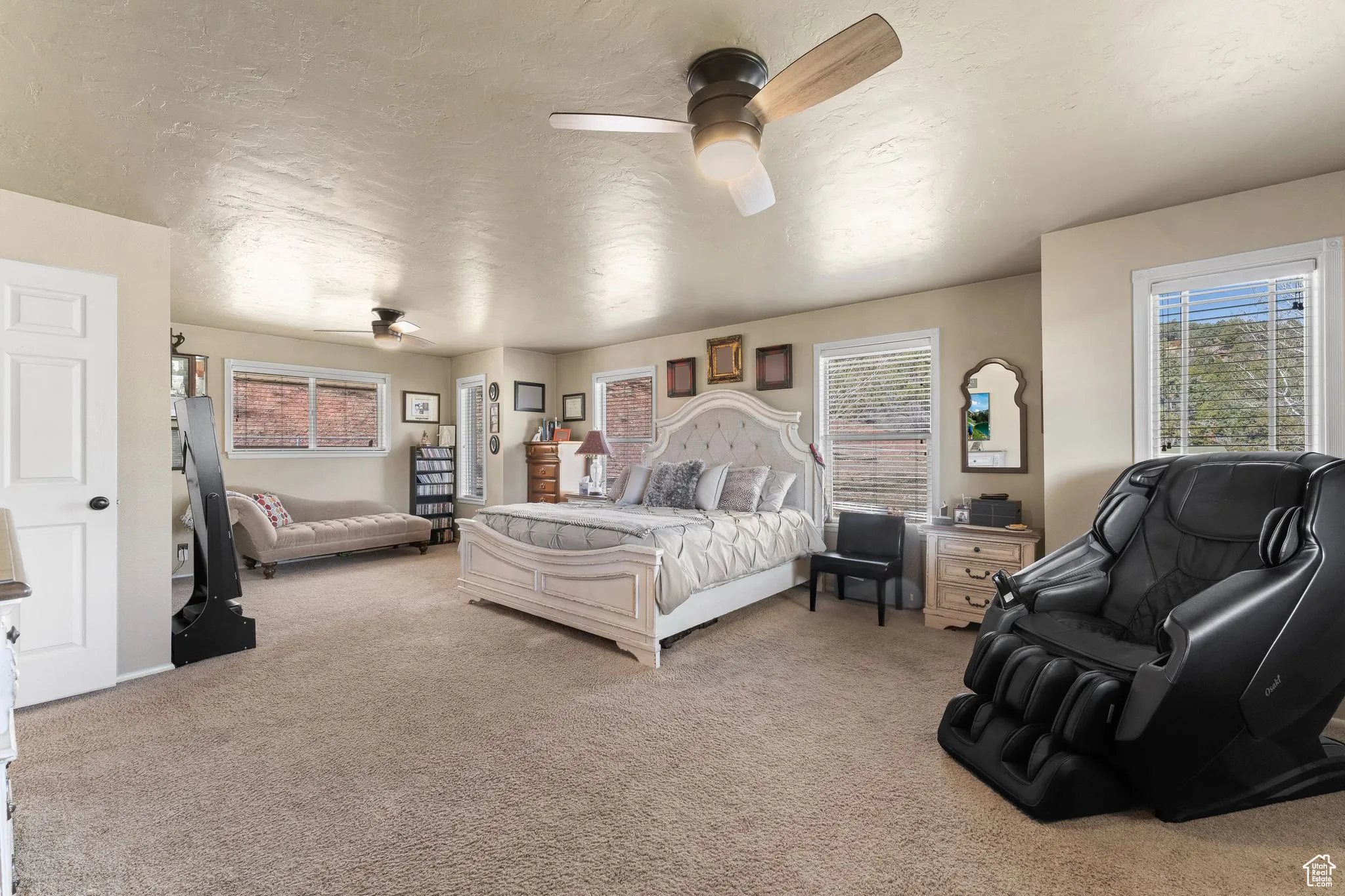 Bedroom featuring light colored carpet, a ceiling fan, and a textured ceiling