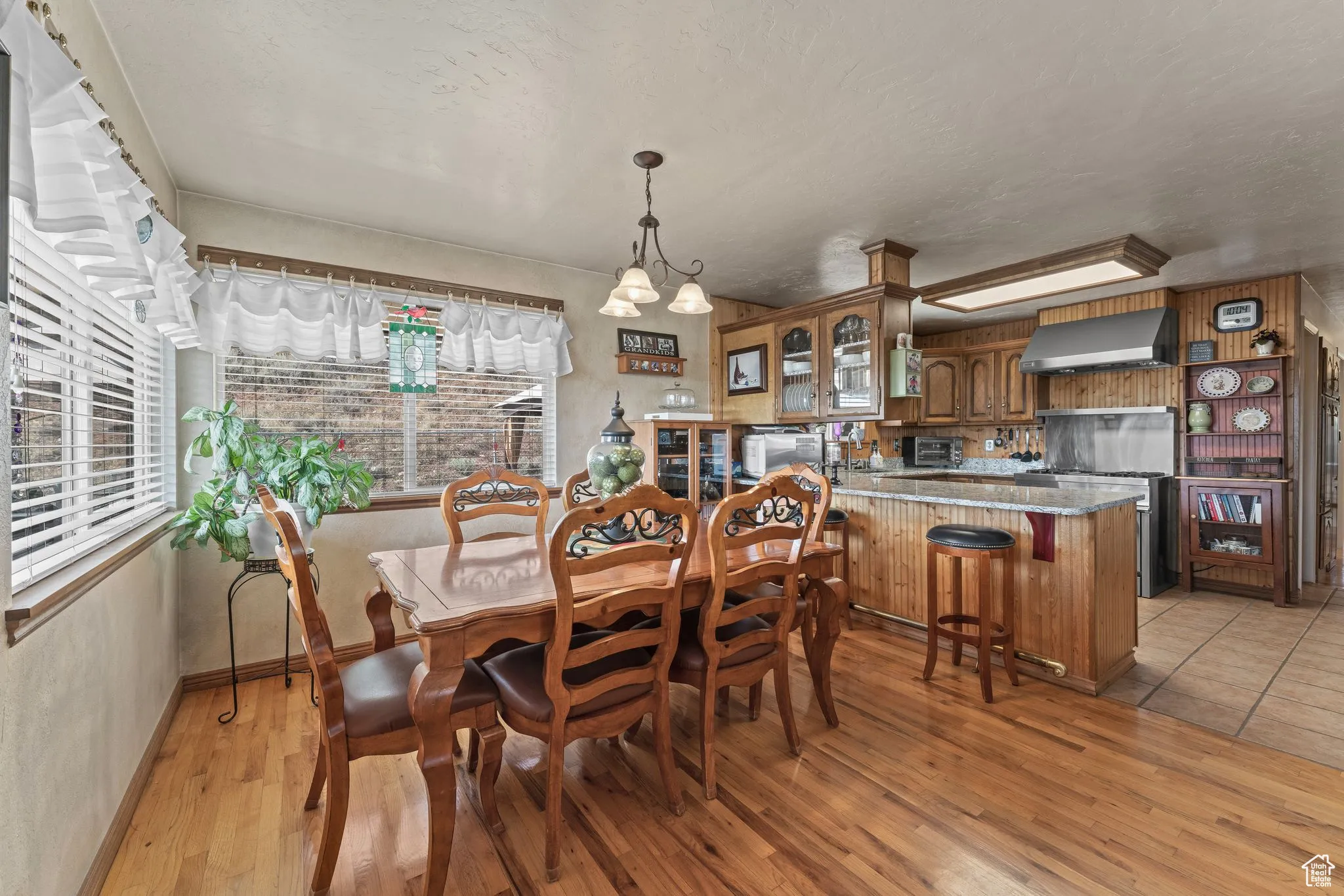 Dining space with plenty of natural light, light wood finished floors, baseboards, and a textured ceiling