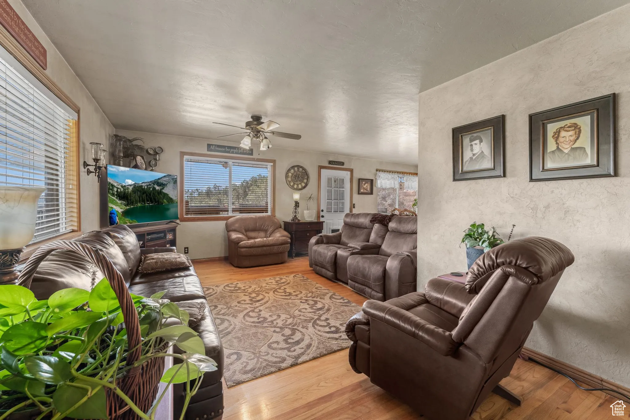Living area with wood finished floors, ceiling fan, and a textured wall