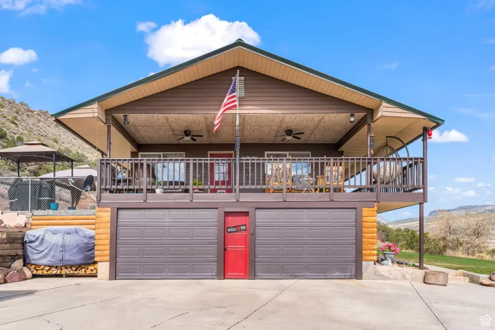 View of front of property featuring ceiling fan, driveway, a garage, and a mountain view