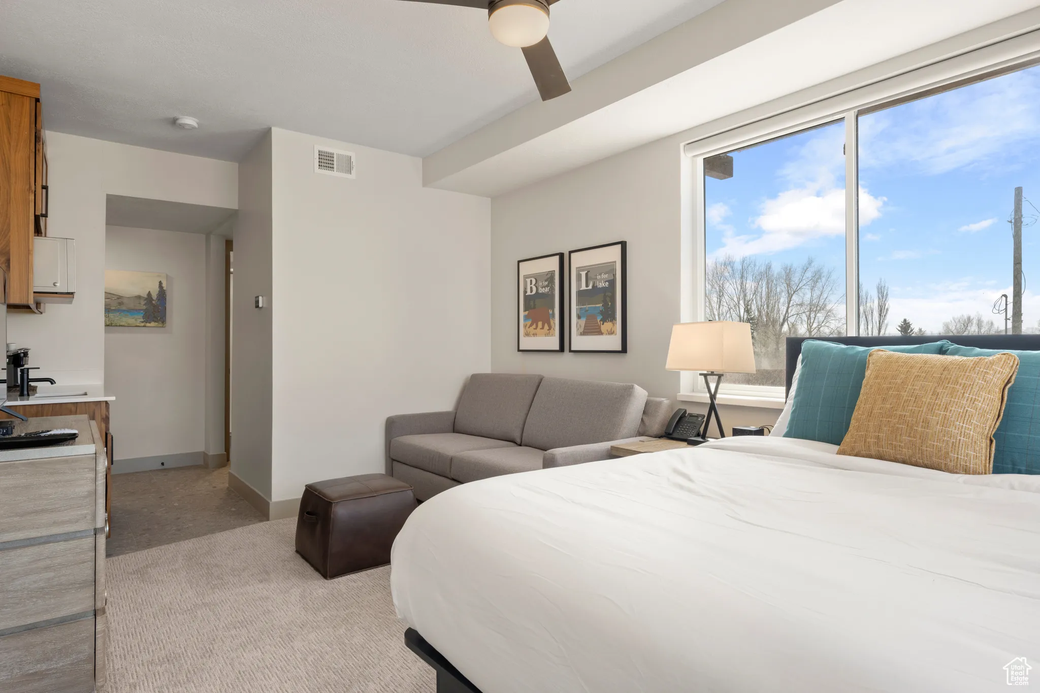 Bedroom featuring light carpet, ceiling fan, and baseboards