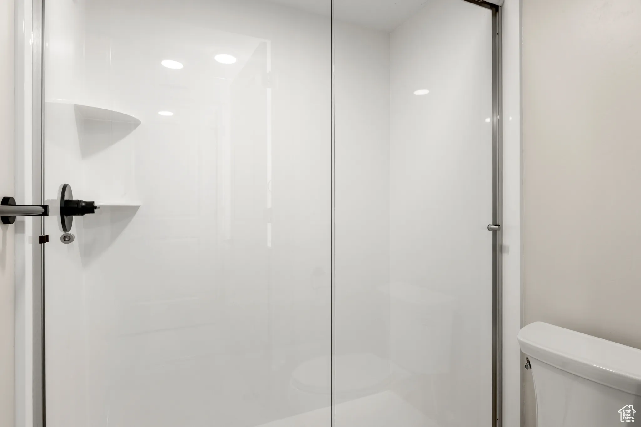 Bathroom featuring toilet and a shower stall