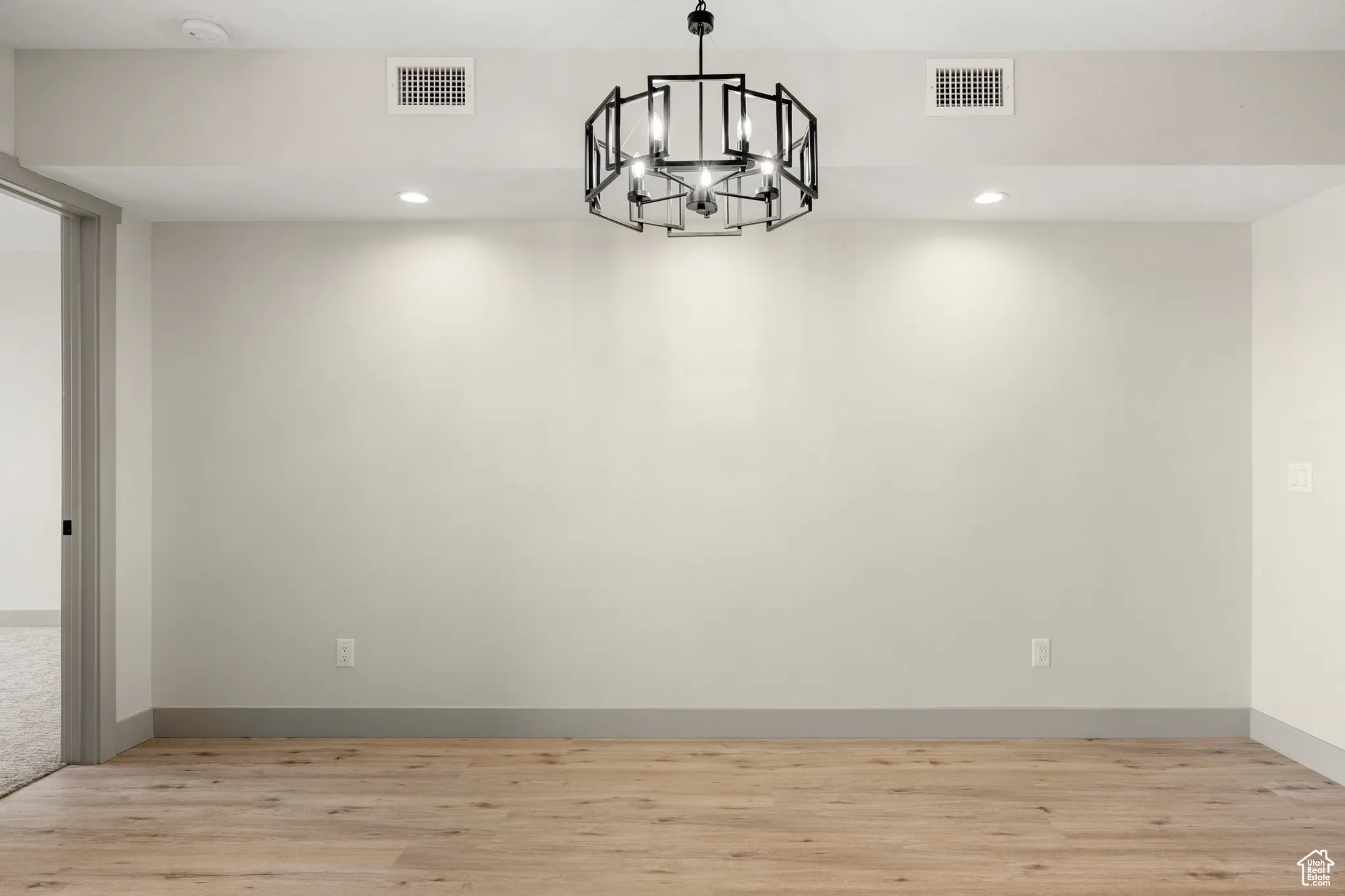 Spare room featuring a chandelier, light wood-style flooring, recessed lighting, a smoke detector, and baseboards