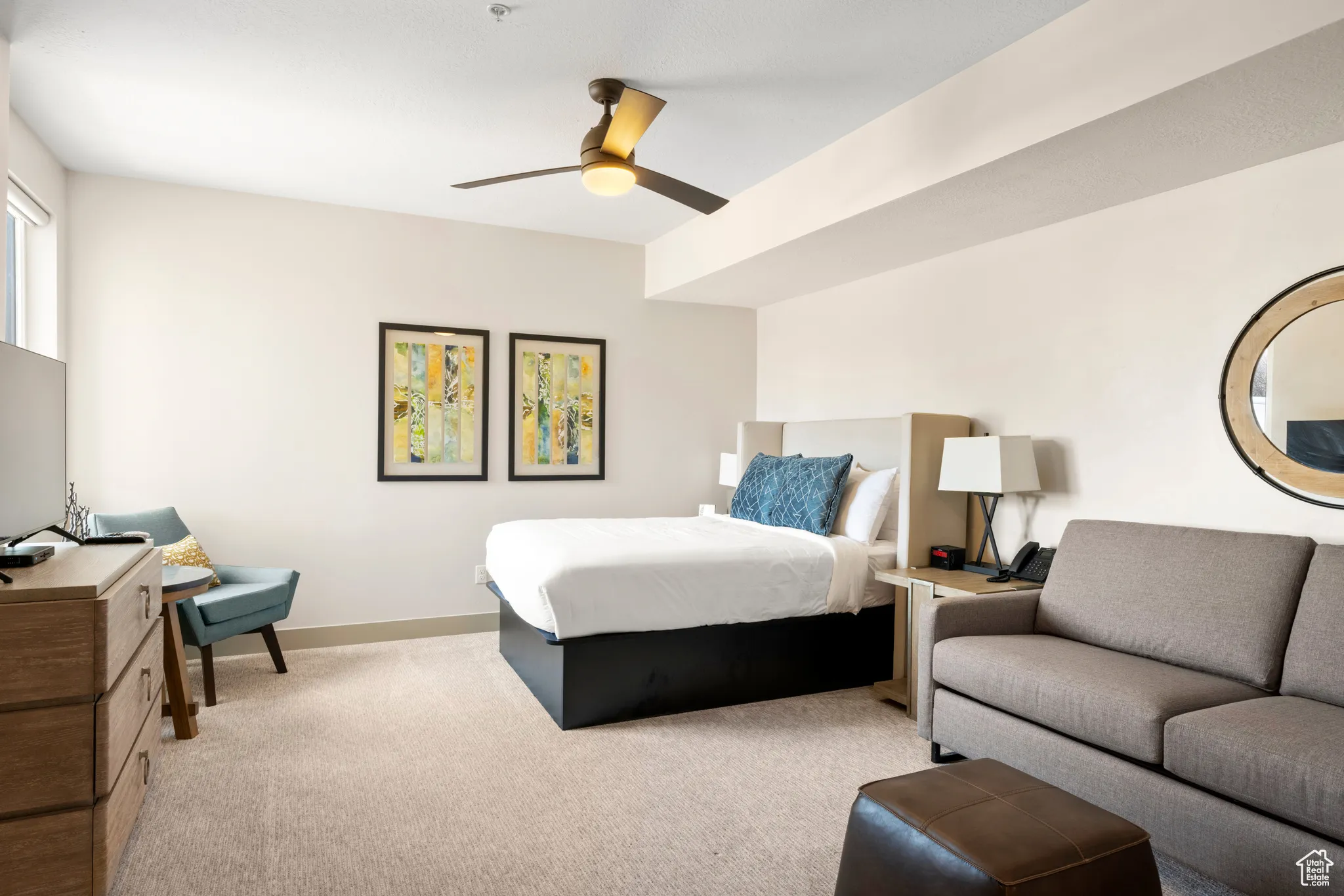 Bedroom featuring light carpet, baseboards, and ceiling fan