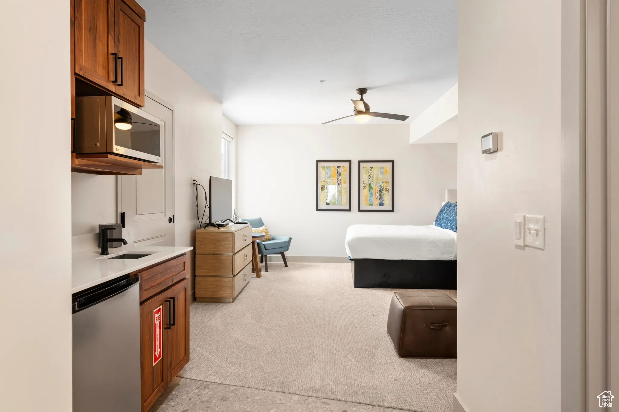 Bedroom with light carpet, a sink, and baseboards