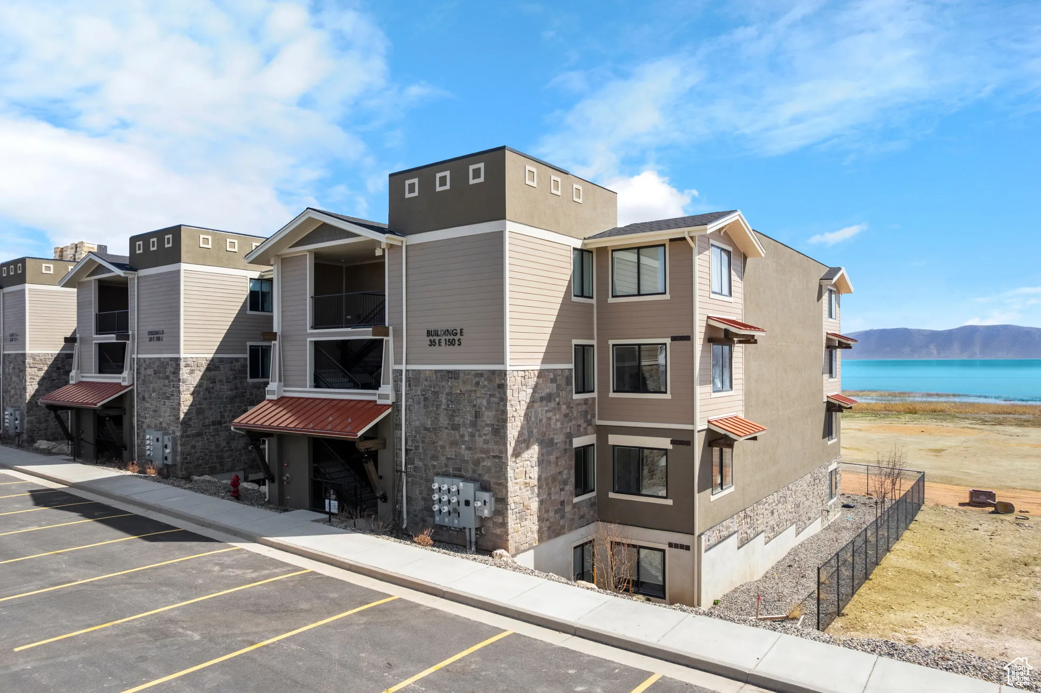 View of building exterior featuring uncovered parking and a water view