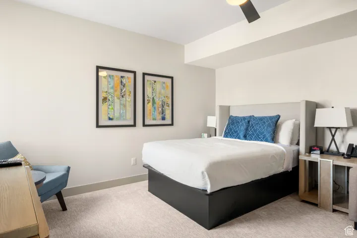 Bedroom featuring light carpet and baseboards