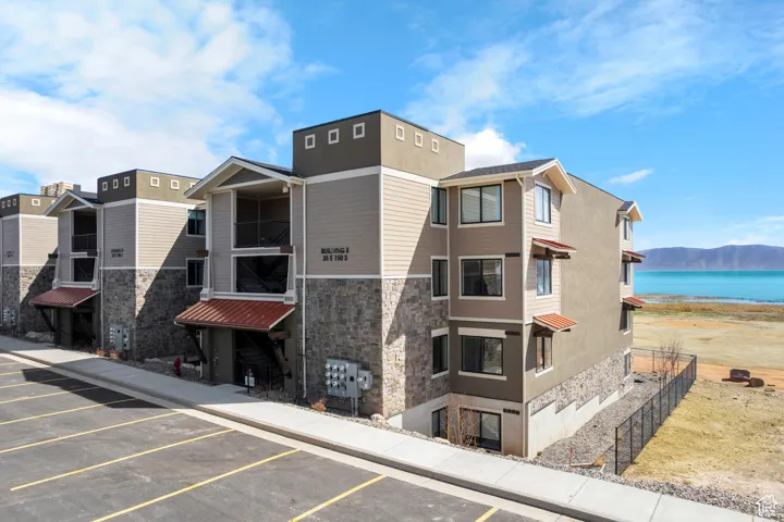 View of building exterior featuring uncovered parking and a water view