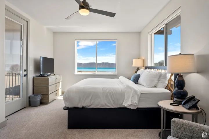Bedroom with carpet, ceiling fan, and access to exterior