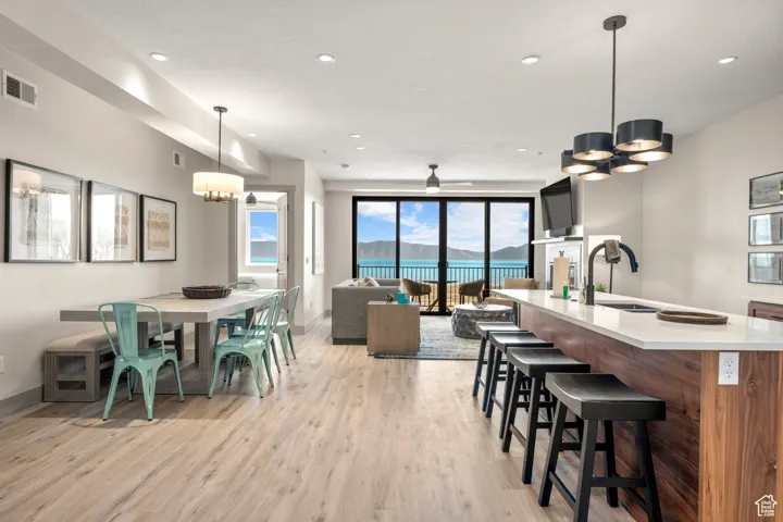 Dining room with a chandelier, light wood-style flooring, baseboards, recessed lighting, and a ceiling fan