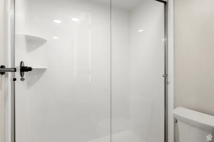 Bathroom featuring toilet and a shower stall