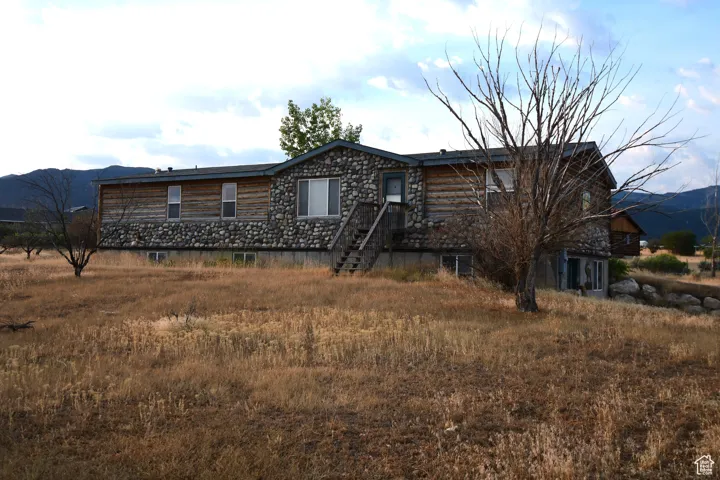 Cabin featuring a mountain view and stone siding