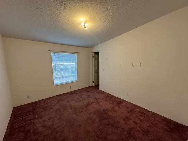 Spare room featuring carpet floors and a textured ceiling