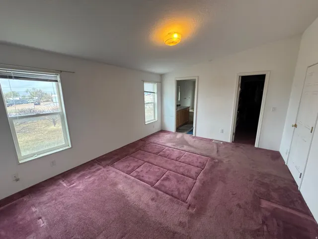 Unfurnished bedroom with carpet floors and ensuite bathroom