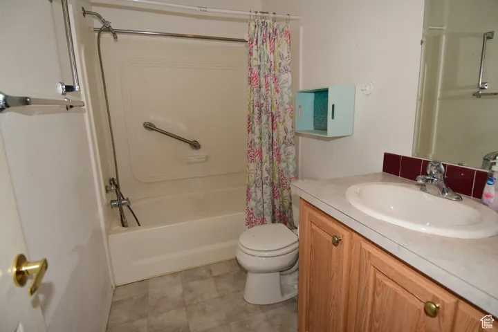 Bathroom with vanity and shower / bath combo with shower curtain