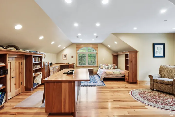 Bedroom with light wood finished floors, vaulted ceiling, and recessed lighting