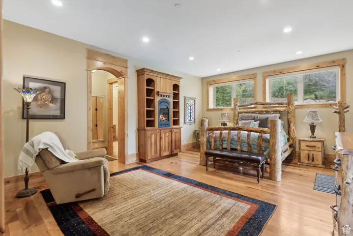 Bedroom featuring light wood finished floors, recessed lighting, baseboards, and arched walkways