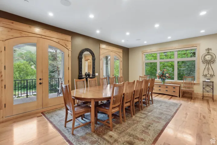 Dining space with french doors, recessed lighting, light wood-type flooring, and arched walkways