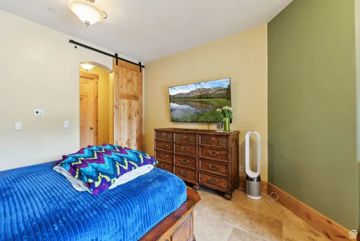 Bedroom with a barn door and baseboards