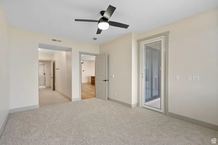 Unfurnished bedroom featuring light colored carpet, access to outside, and ceiling fan
