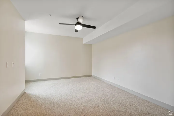 Unfurnished room with light colored carpet and ceiling fan
