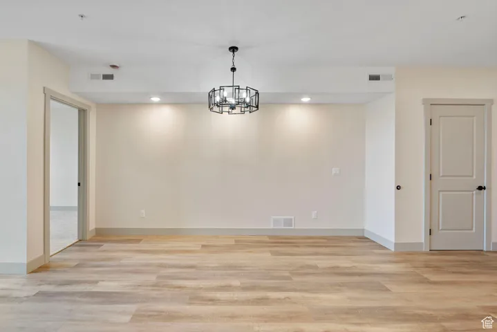 Unfurnished dining area featuring recessed lighting, light wood-type flooring, and a chandelier