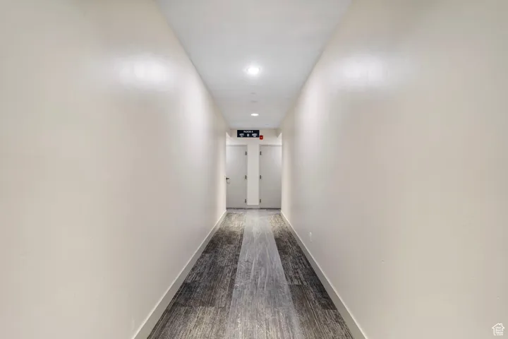 Corridor featuring dark wood finished floors and recessed lighting