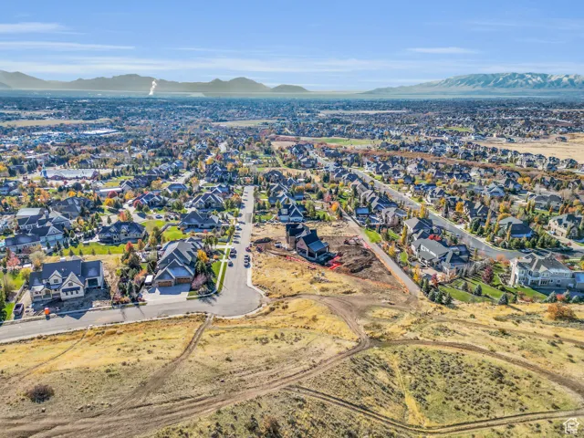 Aerial view of property's location with a mountain backdrop and nearby suburban area
