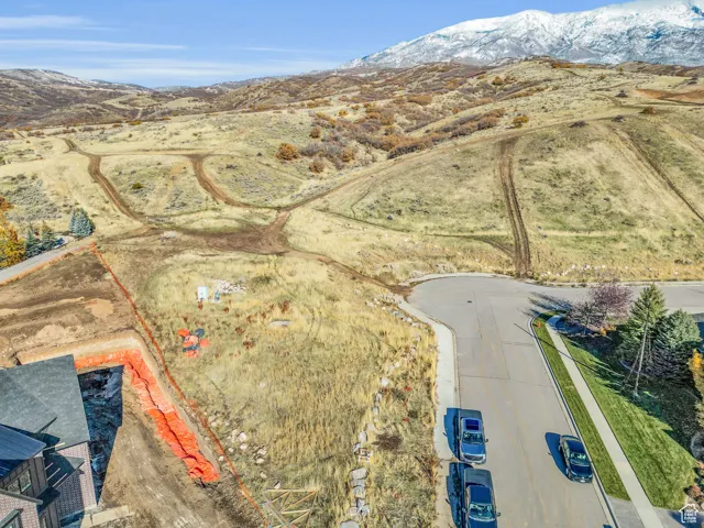 Aerial view of property and surrounding area with a mountain backdrop and property parcel outlined