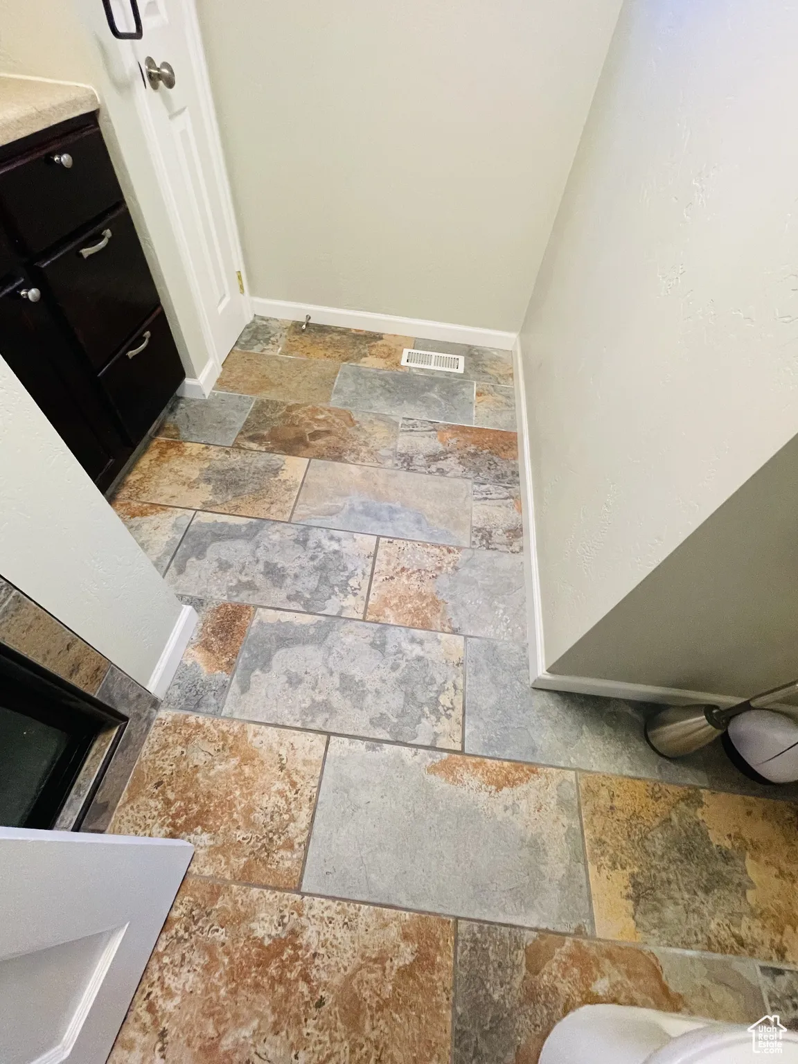 Bathroom with stone tile floors and baseboards