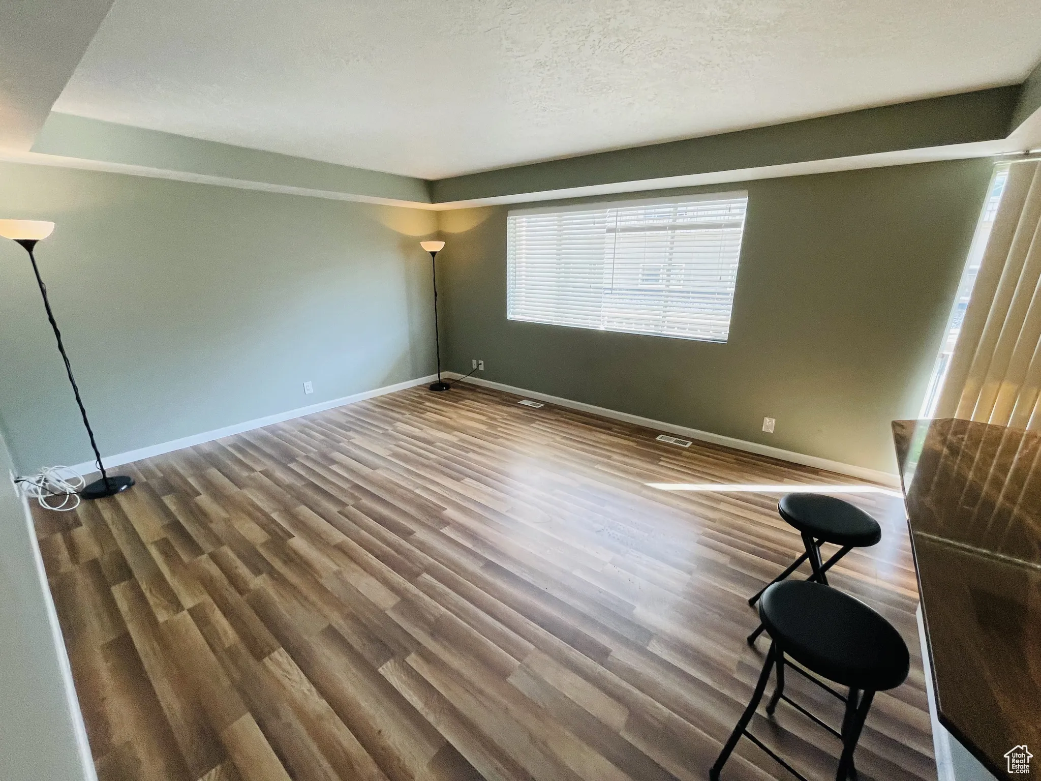 Spare room with wood finished floors, baseboards, and a textured ceiling