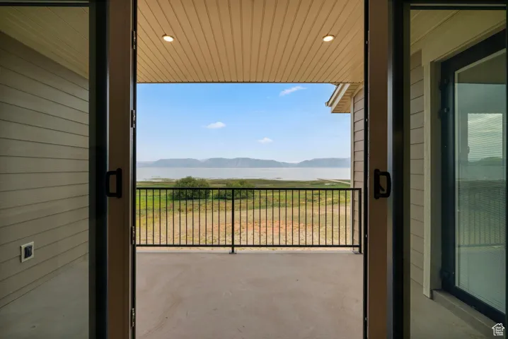 Balcony featuring a water and mountain view