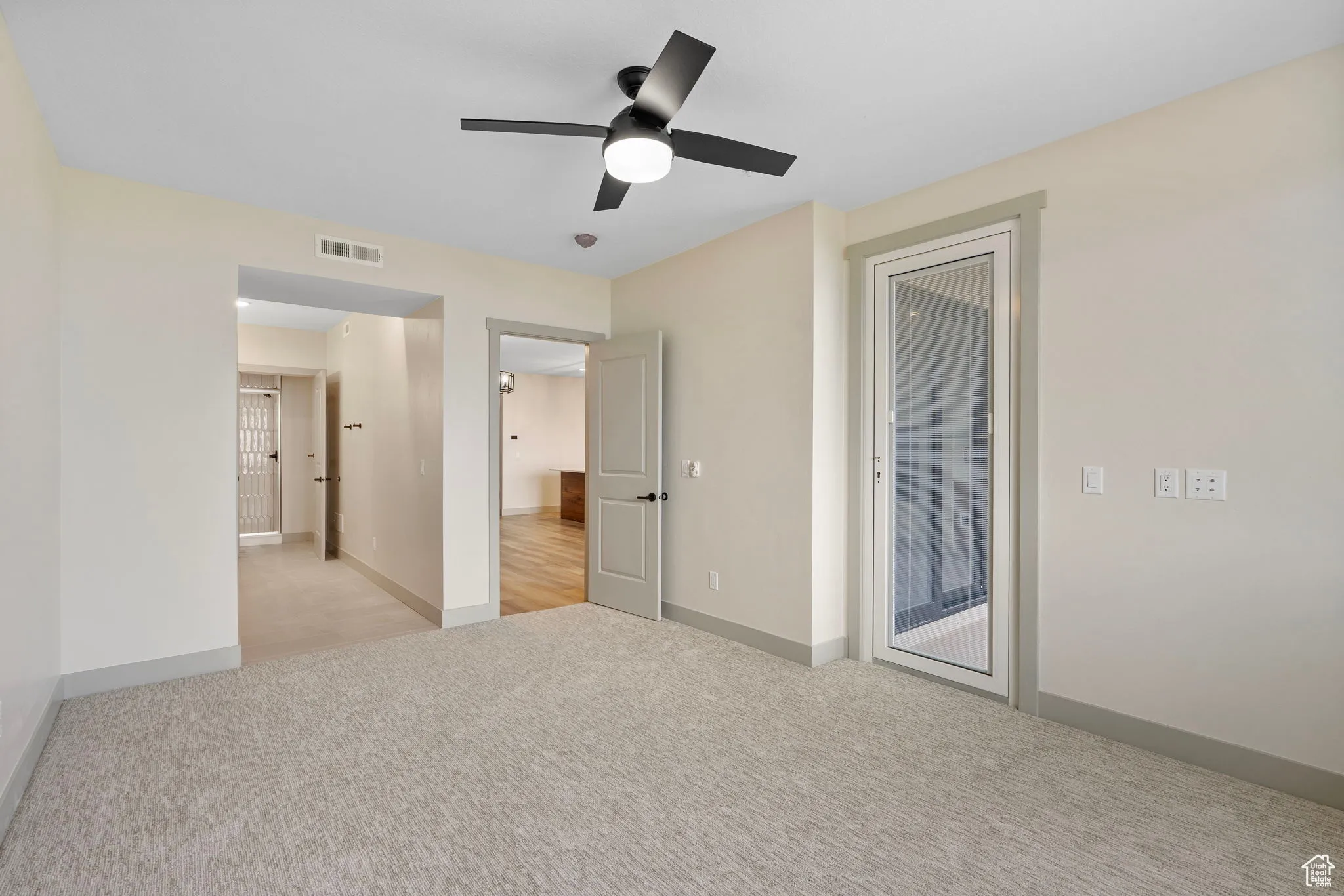 Unfurnished bedroom featuring light colored carpet, access to outside, and ceiling fan