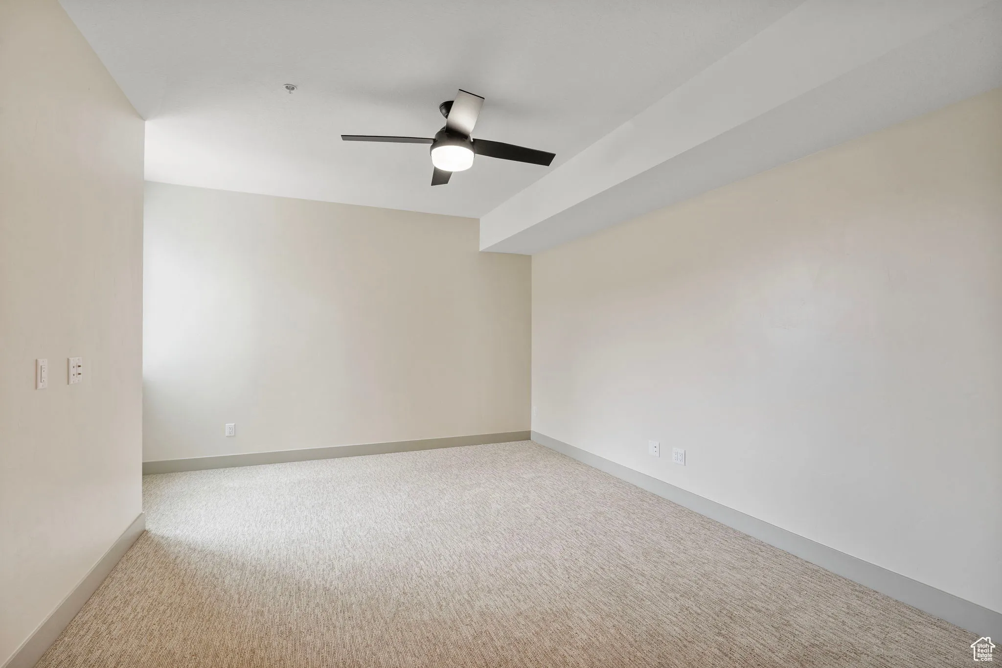 Unfurnished room with light colored carpet and ceiling fan