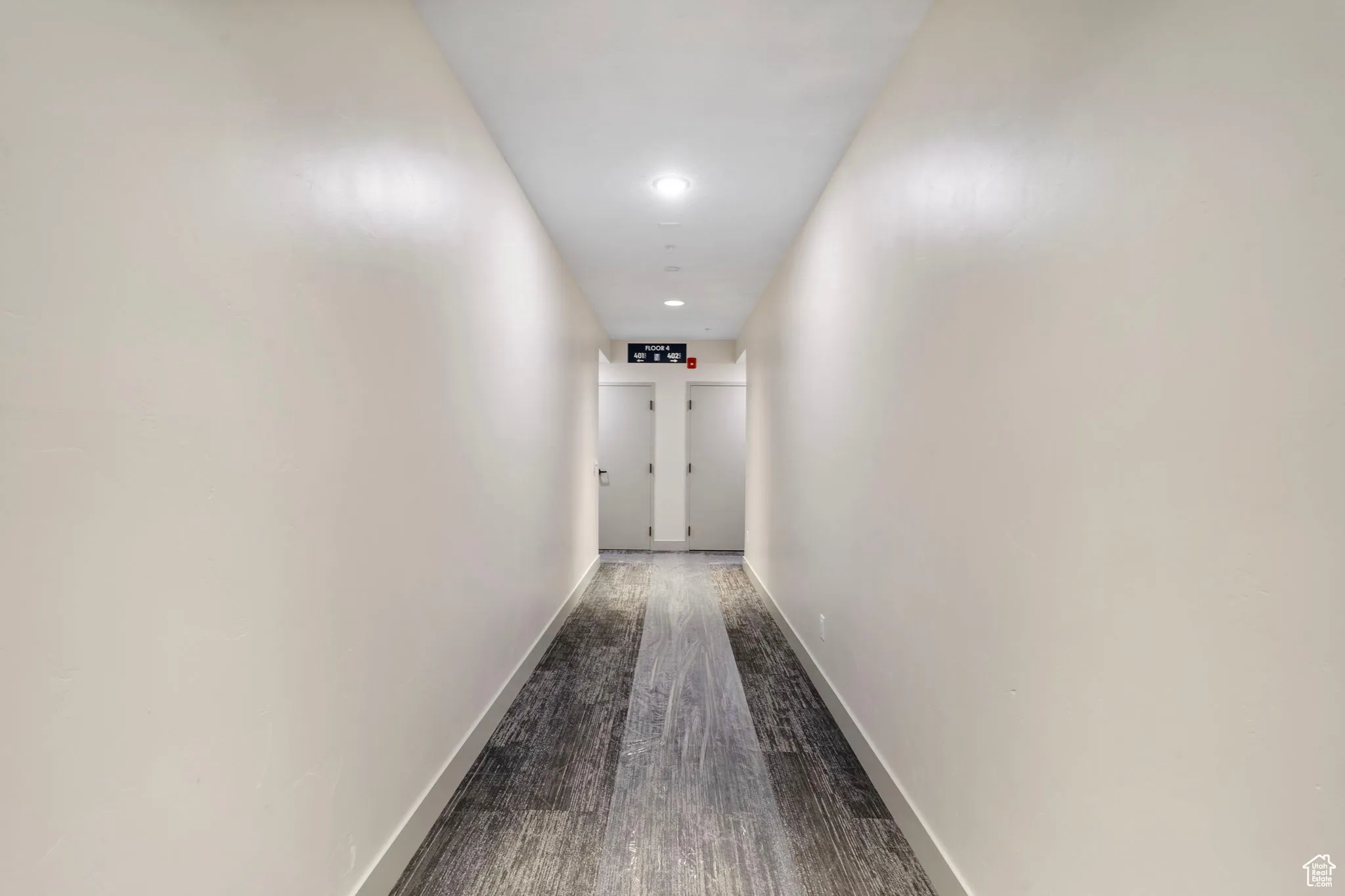 Corridor featuring dark wood finished floors and recessed lighting
