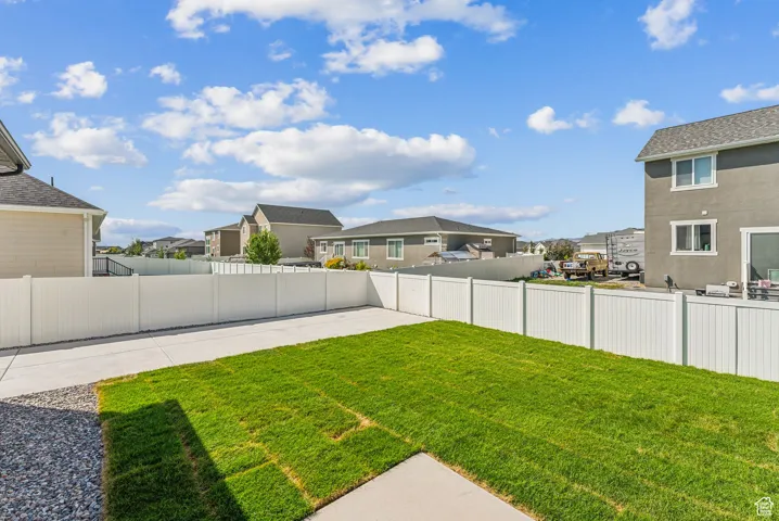 Fenced backyard with a residential view and a patio area