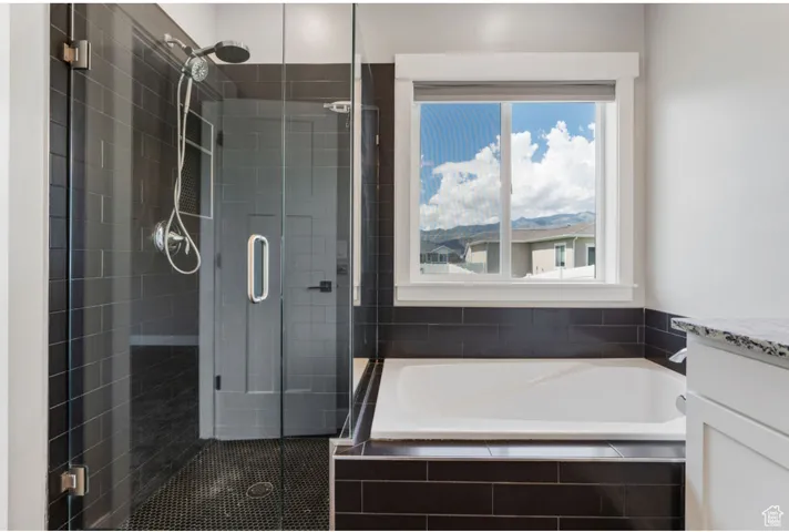 Bathroom with a bath, a stall shower, vanity, and healthy amount of natural light